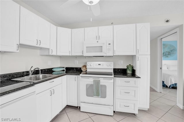 kitchen with white appliances, light tile patterned floors, ceiling fan, a sink, and white cabinets