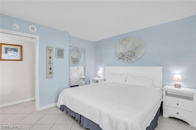 bedroom with light tile patterned floors and baseboards