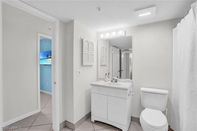 bathroom with tile patterned floors, baseboards, and toilet