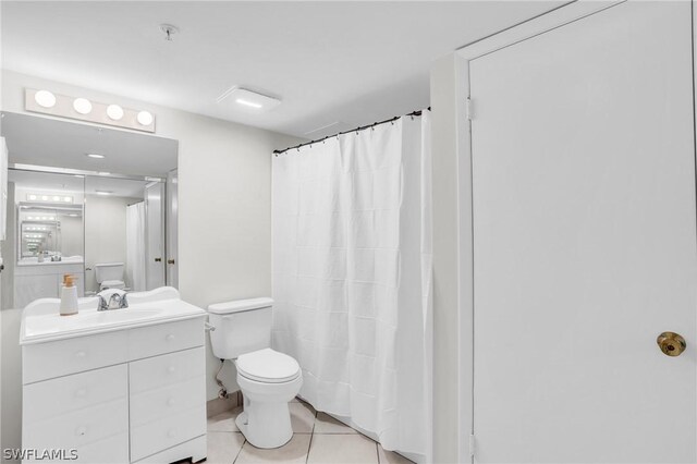 full bath with toilet, vanity, and tile patterned flooring