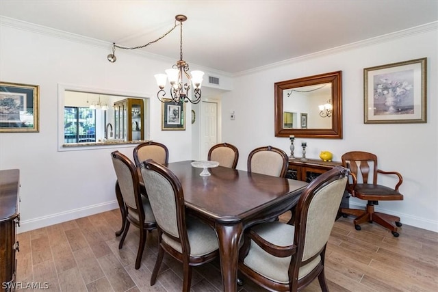 dining space featuring light wood-type flooring, crown molding, and a notable chandelier