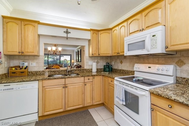 kitchen featuring sink, an inviting chandelier, dark stone counters, white appliances, and light tile patterned floors