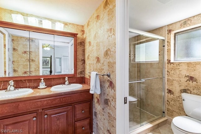 bathroom featuring tile patterned flooring, vanity, toilet, and a shower with shower door