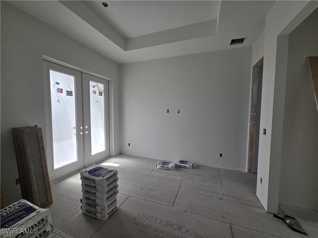 interior space with french doors and a raised ceiling