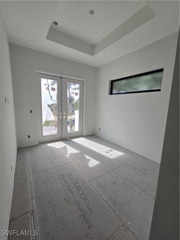 spare room with a raised ceiling and french doors