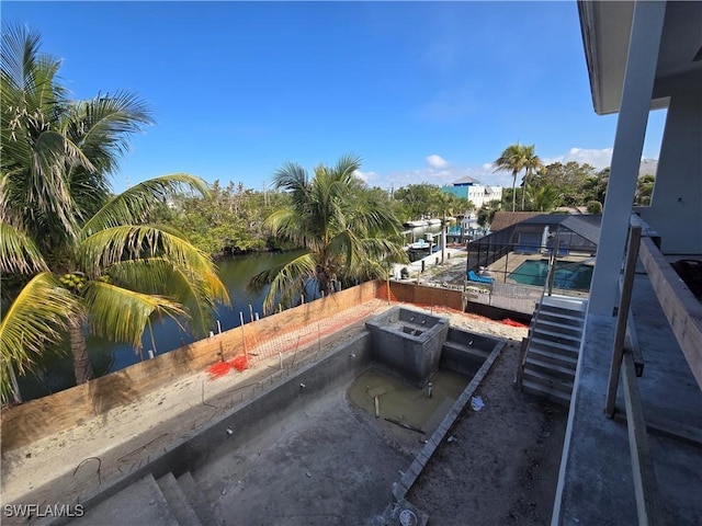 view of patio with a fenced in pool and a water view