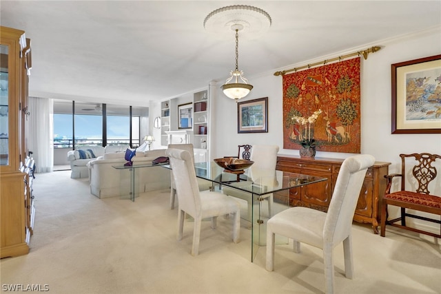 dining area with expansive windows, ornamental molding, and light carpet