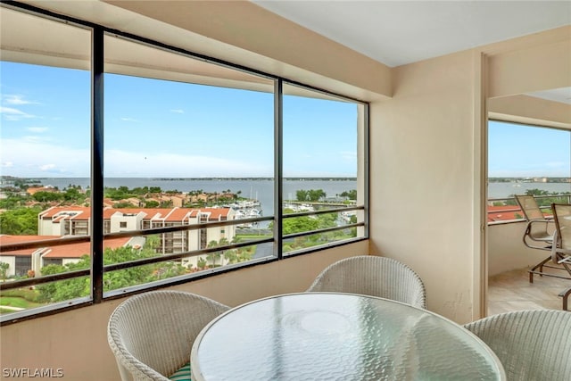 sunroom featuring a water view