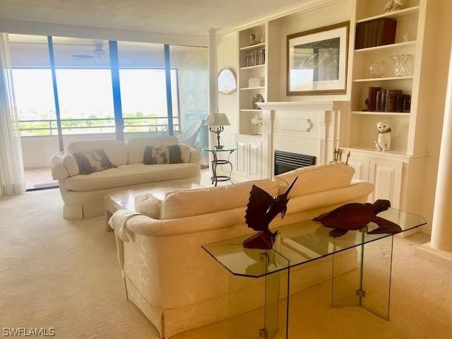 carpeted living room with built in shelves and a fireplace