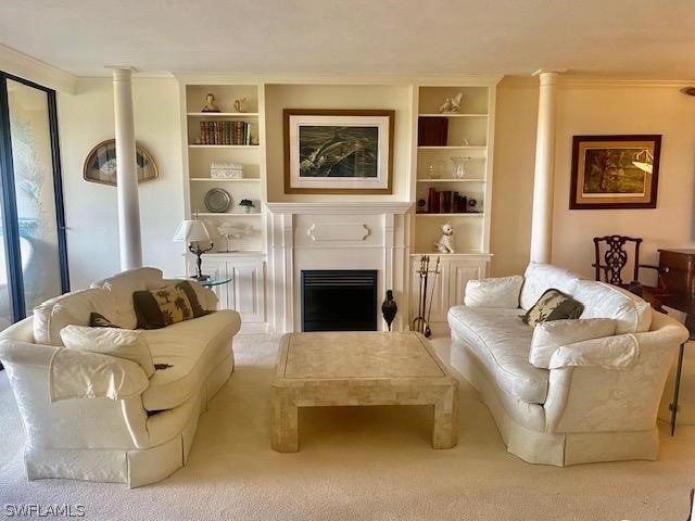 living area with built in shelves, a fireplace, crown molding, and carpet flooring