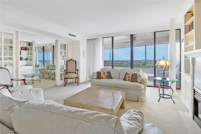 carpeted living room featuring decorative columns and ceiling fan