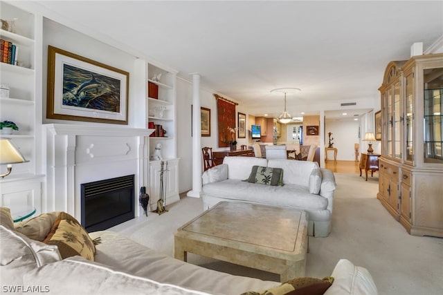 living room with built in shelves, light carpet, and crown molding