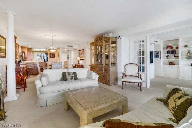 living area with light colored carpet and ornate columns