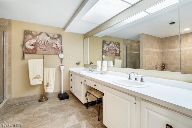 bathroom with a shower with shower door and vanity