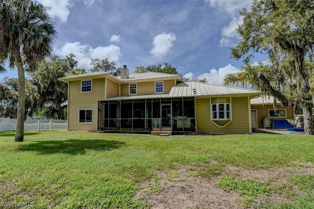 back of property featuring a sunroom and a lawn