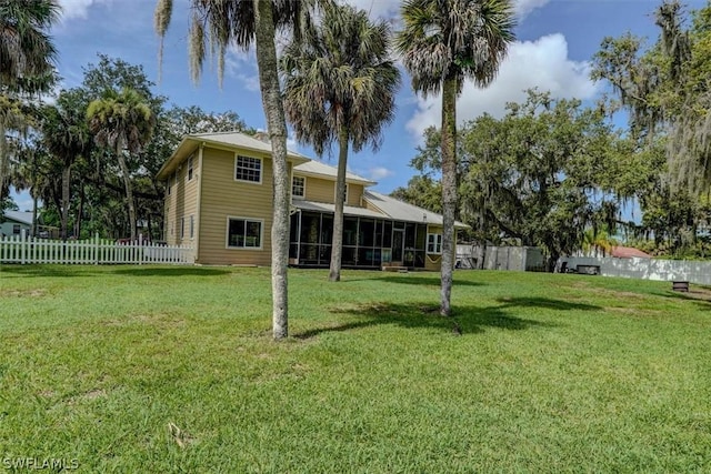 back of property featuring a yard and a sunroom