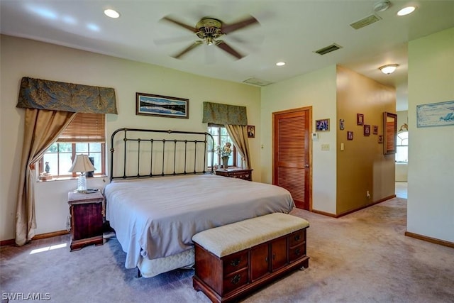 carpeted bedroom featuring multiple windows, ceiling fan, and a closet