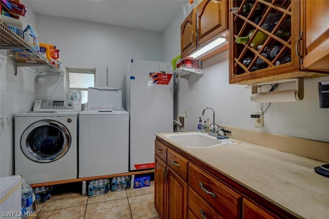 washroom with cabinets, separate washer and dryer, sink, and light tile patterned floors