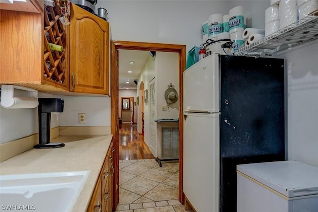 kitchen featuring light tile patterned flooring and refrigerator