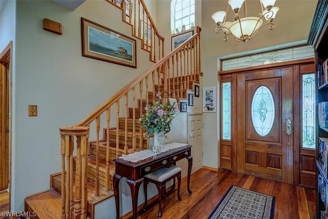 foyer with a high ceiling, a notable chandelier, and dark hardwood / wood-style flooring