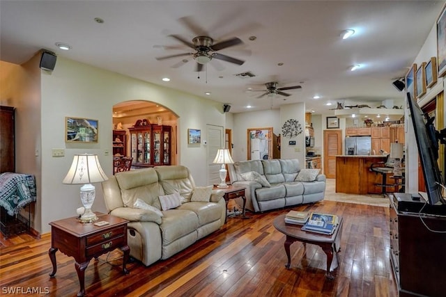 living room with dark wood-type flooring and ceiling fan