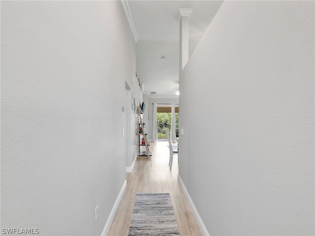 hall with light hardwood / wood-style floors and ornamental molding