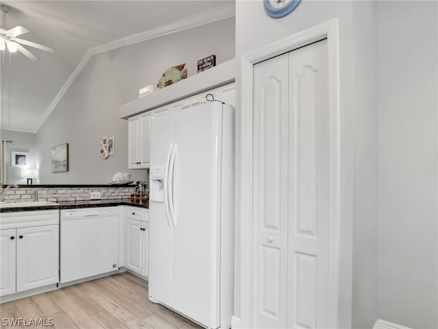 kitchen featuring sink, backsplash, lofted ceiling, white appliances, and white cabinets