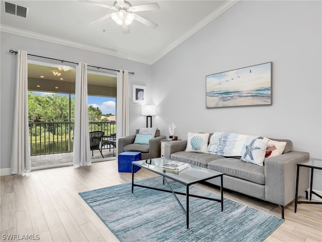 living room with light wood-type flooring, ceiling fan, and ornamental molding