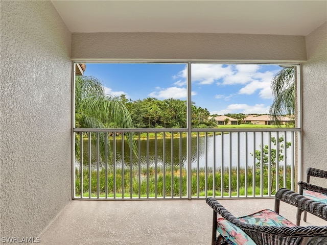 sunroom featuring a water view and a healthy amount of sunlight