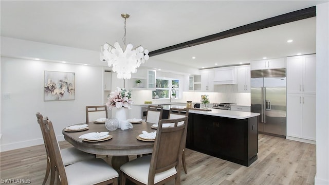 dining room featuring beamed ceiling, light hardwood / wood-style flooring, and a chandelier