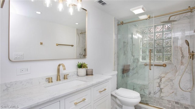 bathroom featuring vanity, toilet, and a shower with door