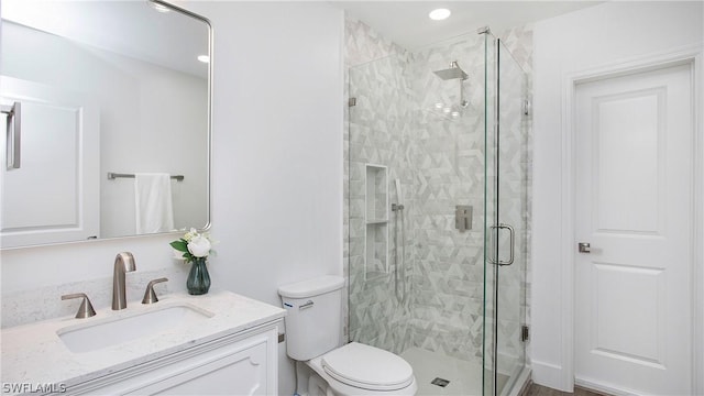 bathroom featuring vanity, toilet, and walk in shower