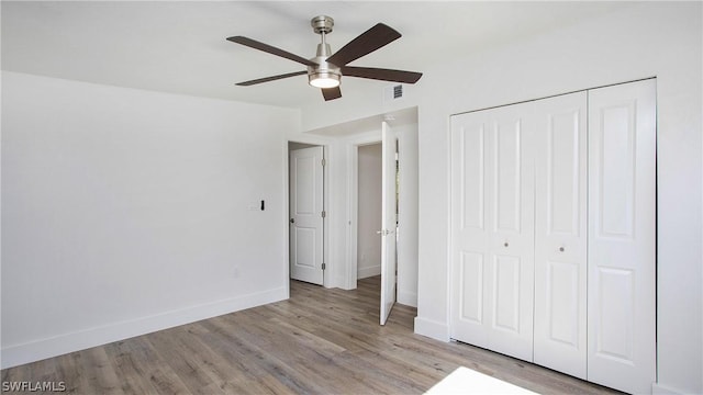 unfurnished bedroom with ceiling fan, light hardwood / wood-style floors, and a closet