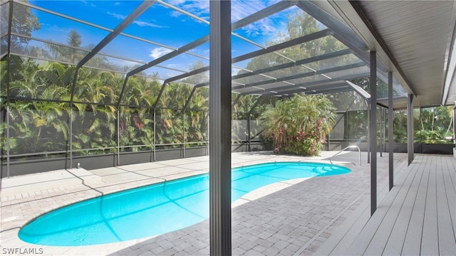 view of swimming pool with glass enclosure and a patio area