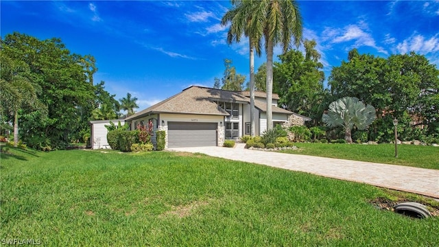 ranch-style home featuring a front yard and a garage