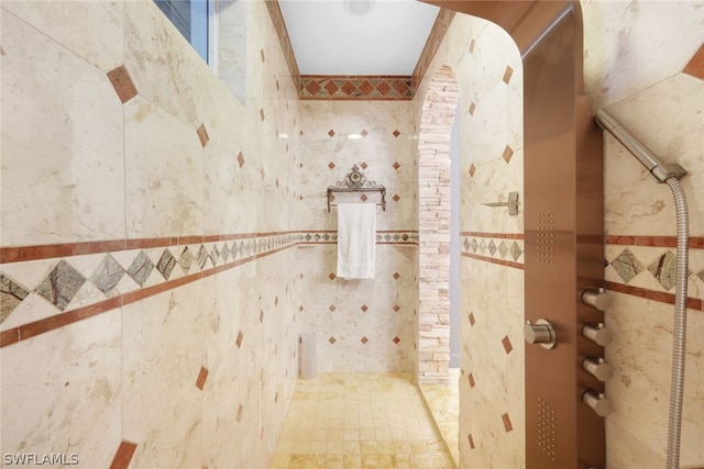 bathroom with tile walls and walk in shower