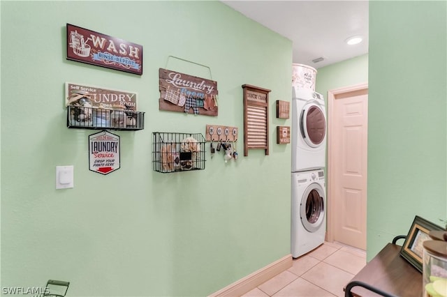 laundry room featuring stacked washing maching and dryer and light tile patterned flooring