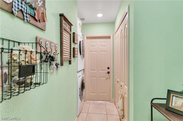 hallway with stacked washer and dryer and light tile patterned floors