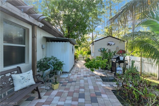 view of patio featuring a shed and grilling area