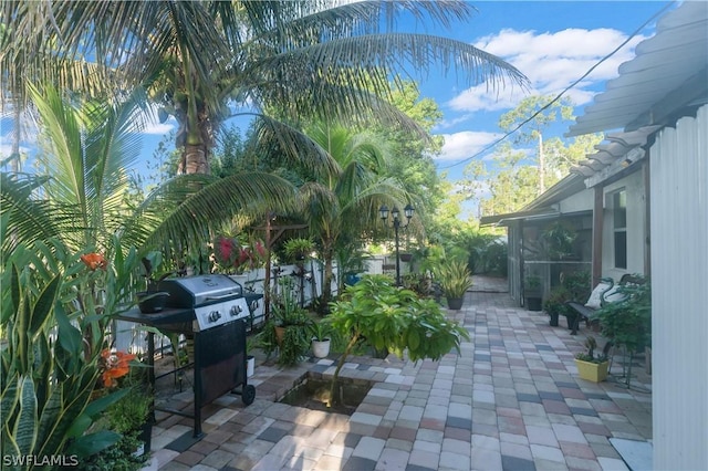 view of patio / terrace featuring a grill and a sunroom