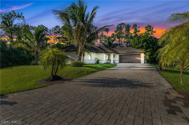 view of front of property featuring a lawn and a garage