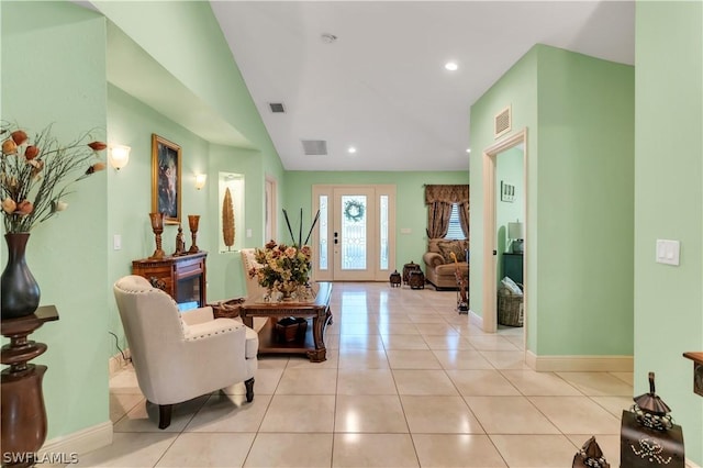 foyer featuring lofted ceiling and light tile patterned flooring