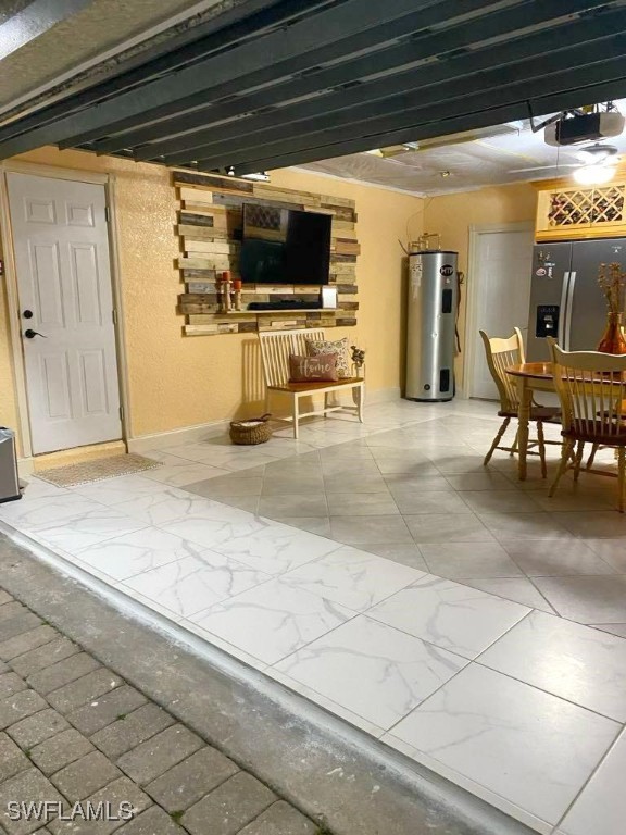 basement with water heater and stainless steel fridge