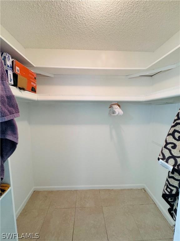 walk in closet with light tile patterned floors