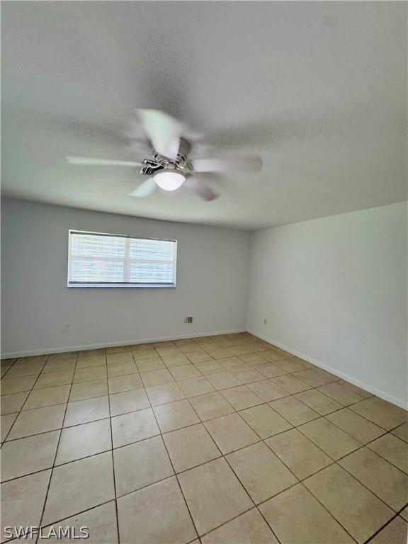 tiled empty room featuring a textured ceiling and ceiling fan