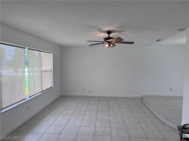 tiled spare room featuring ceiling fan and a textured ceiling