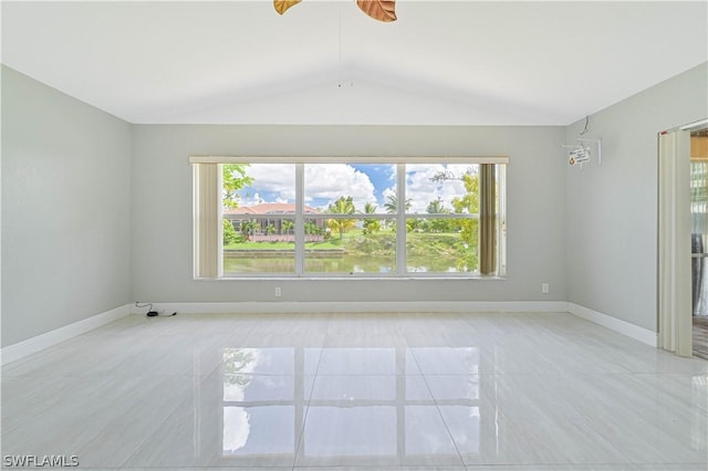 empty room with vaulted ceiling and a water view