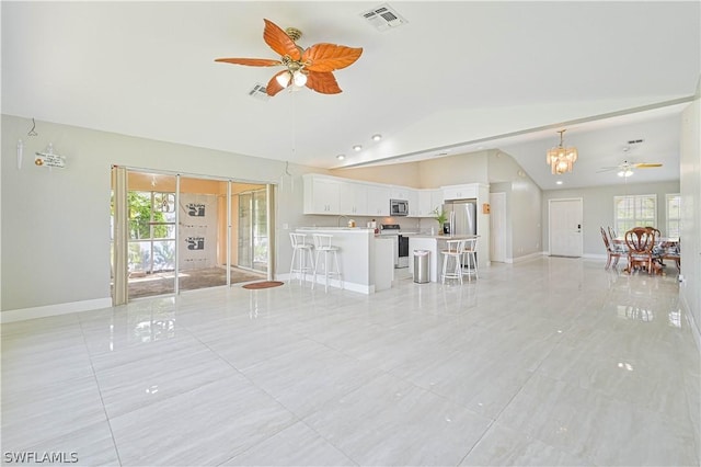 unfurnished living room featuring lofted ceiling, plenty of natural light, and ceiling fan