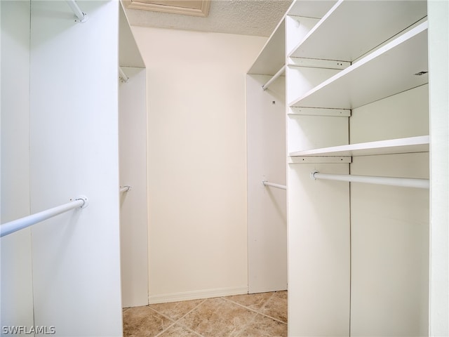 spacious closet featuring light tile patterned floors