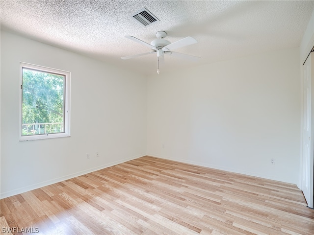 empty room featuring ceiling fan, a textured ceiling, and light hardwood / wood-style flooring